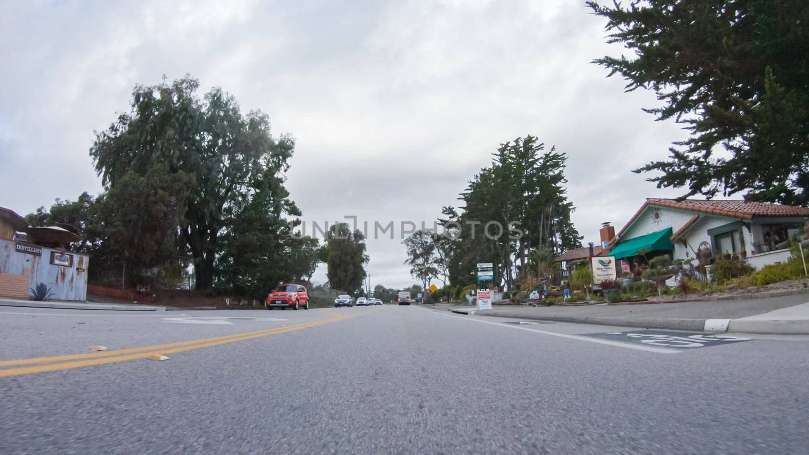 Santa Maria, California, USA-December 6, 2022-Vehicle navigates the streets of Morro Bay, California, during a cloudy winter day. The atmosphere is moody and serene as the overcast sky casts a soft light on the charming buildings and quiet streets of this coastal town.