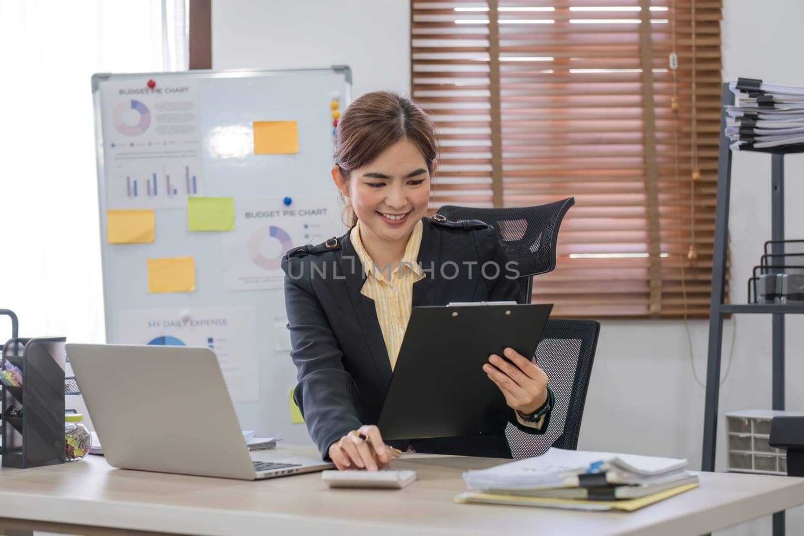 Business woman using calculator and laptop for do math finance on wooden desk in office and business working background, tax, accounting, statistics and analytic research concept.