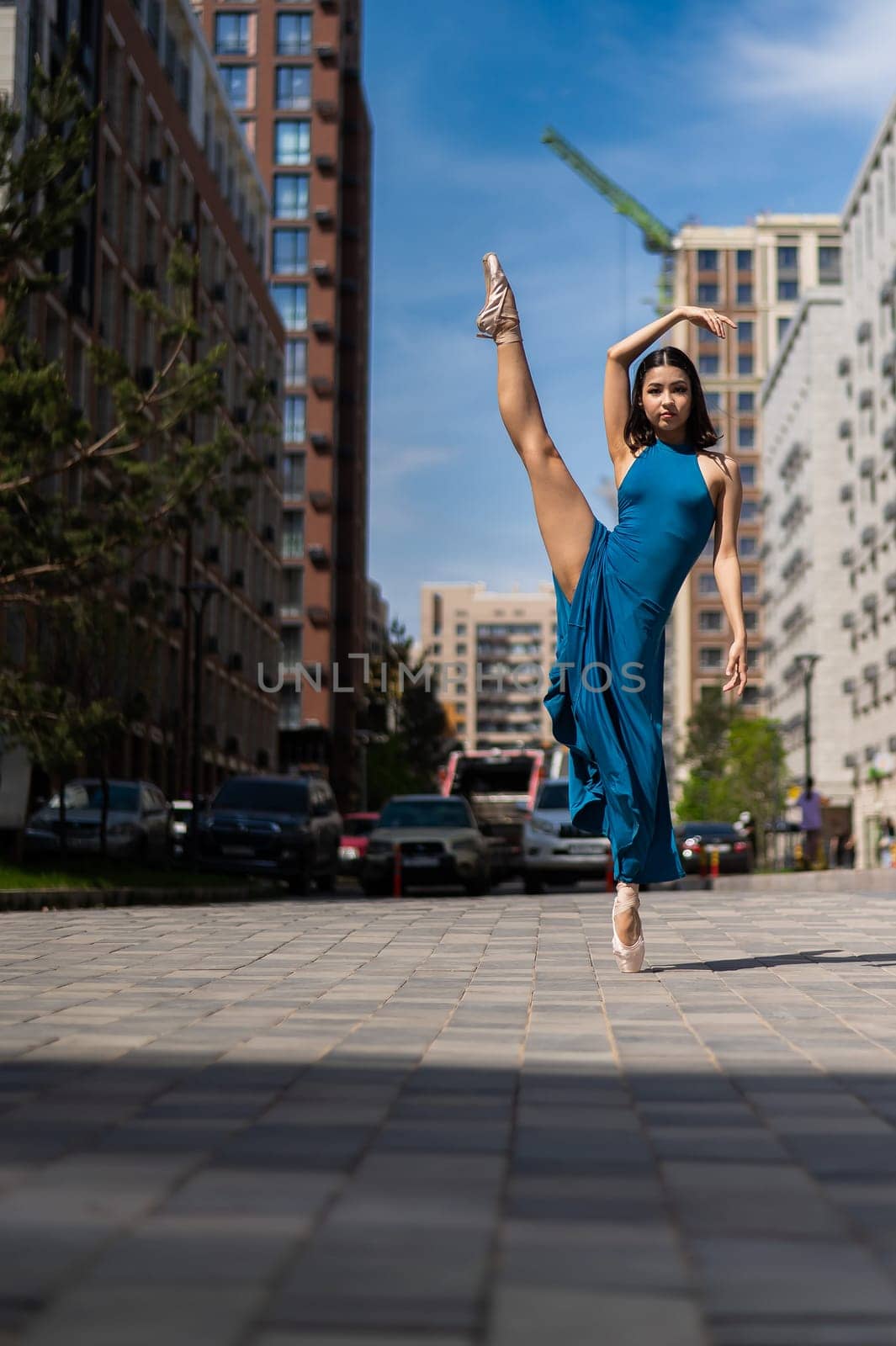 Beautiful Asian ballerina dancing outdoors. Urban landscape