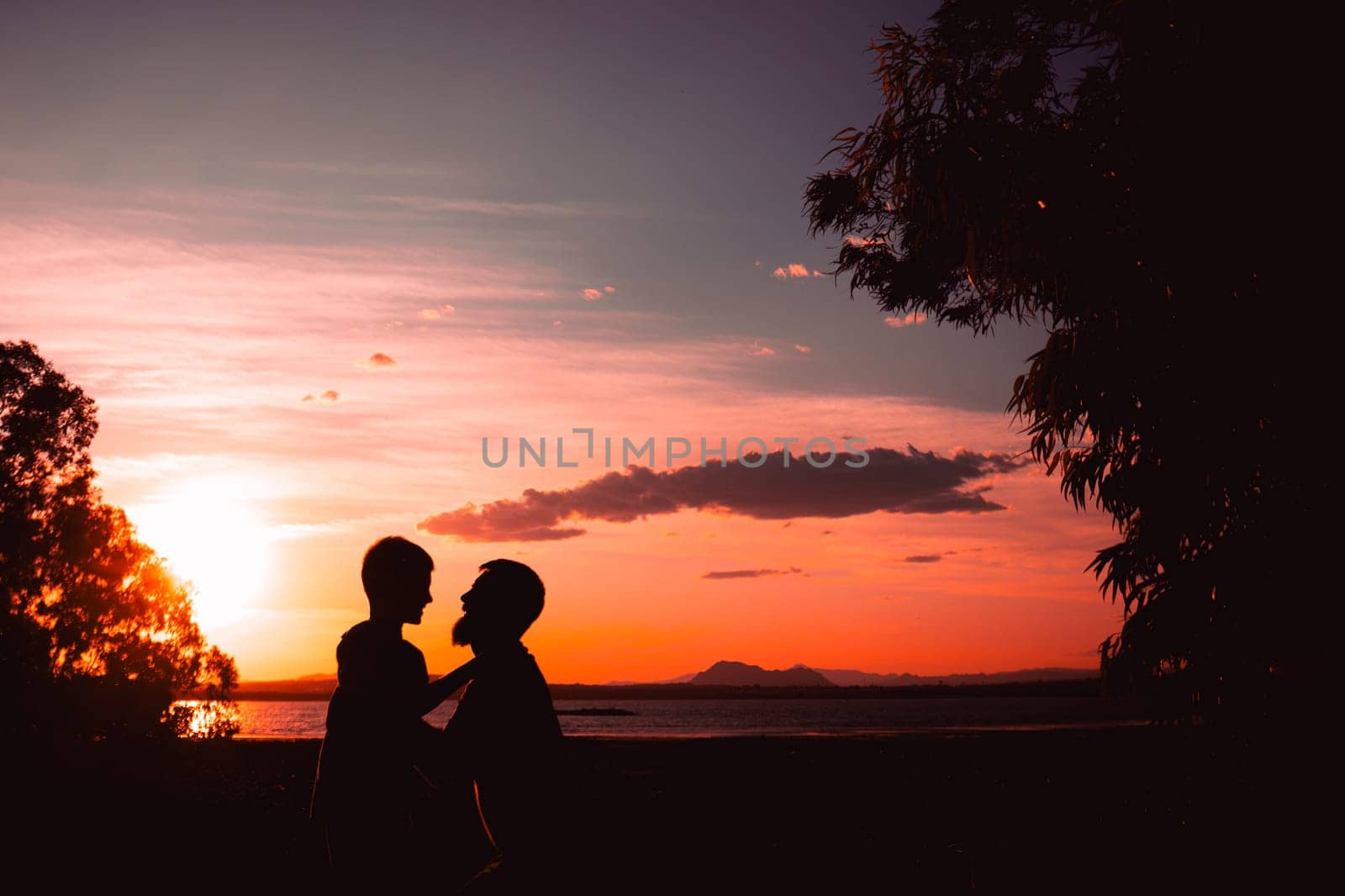 Father and son playing in the park at the sunset time. People having fun on the field. Concept of friendly family and of summer vacation. High quality photo