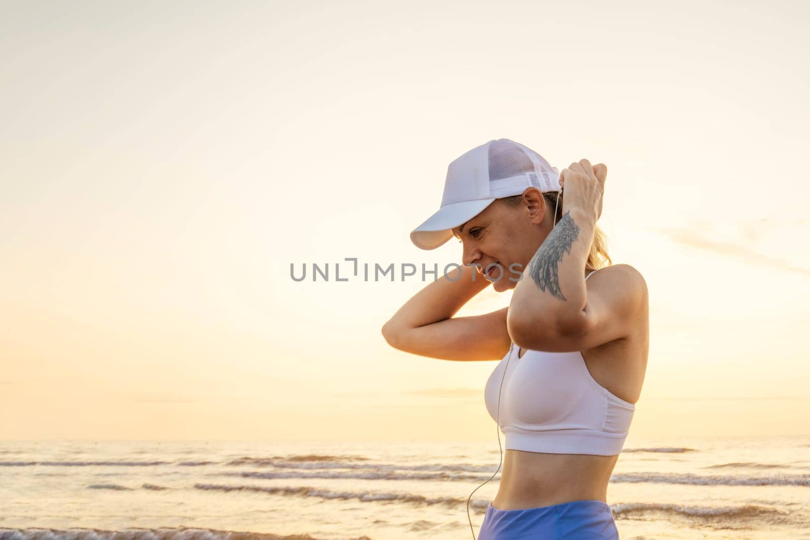 sports girl stands against the background of the sea in sportswear,there is place for an inscription by PopOff