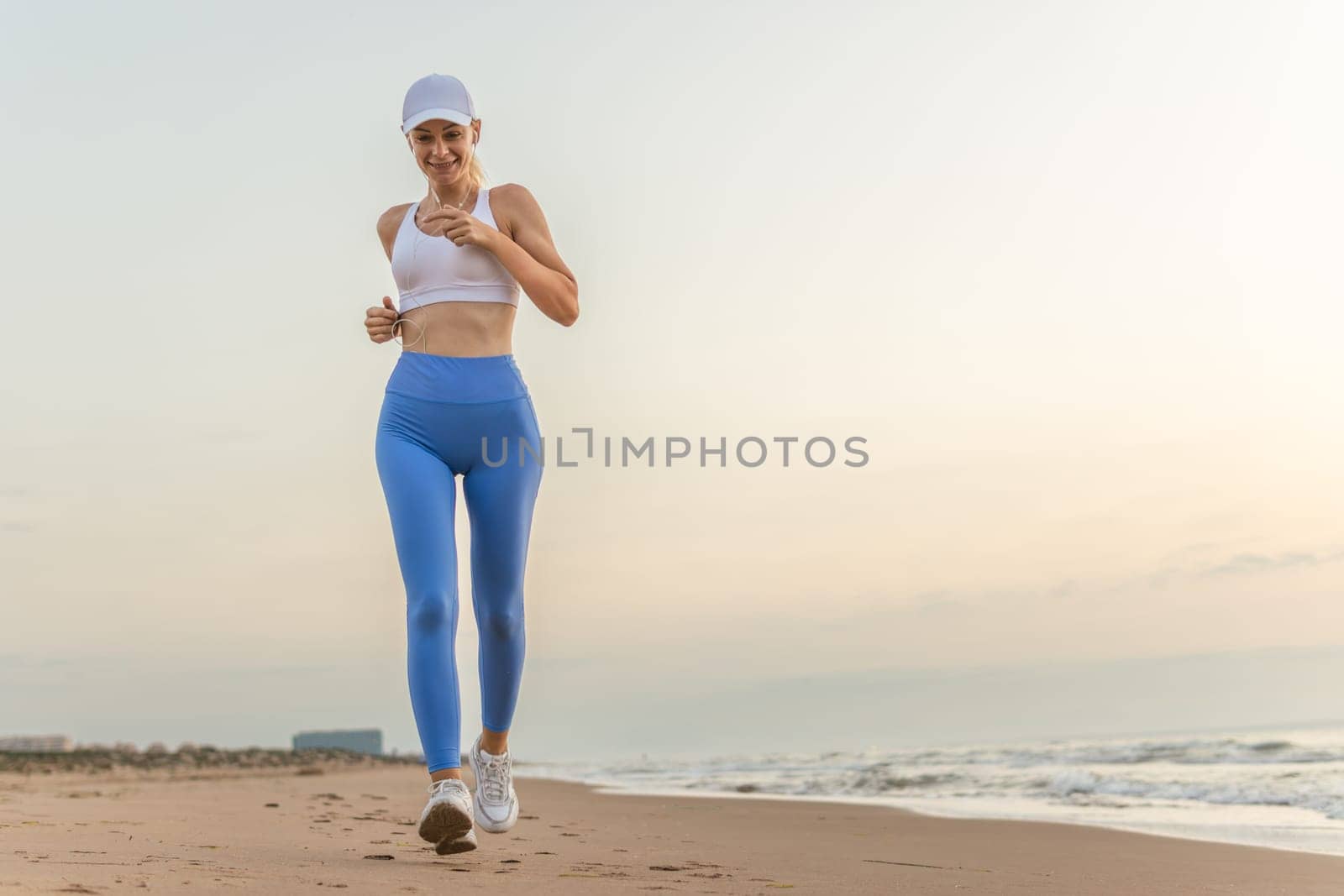 sportive woman running along beautiful sandy beach, healthy lifestyle, enjoying active summer vacation near the sea. High quality photo