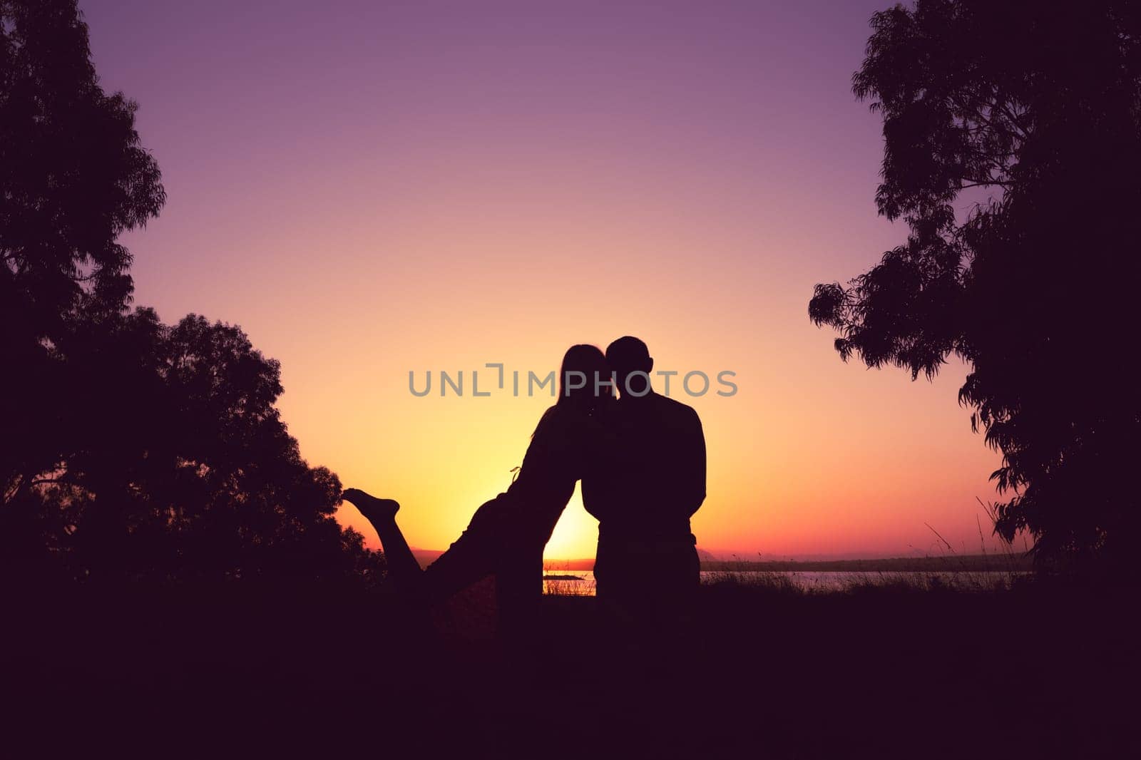 silhouette of a couple in love at sunset against a background of nature, there is a place for by PopOff