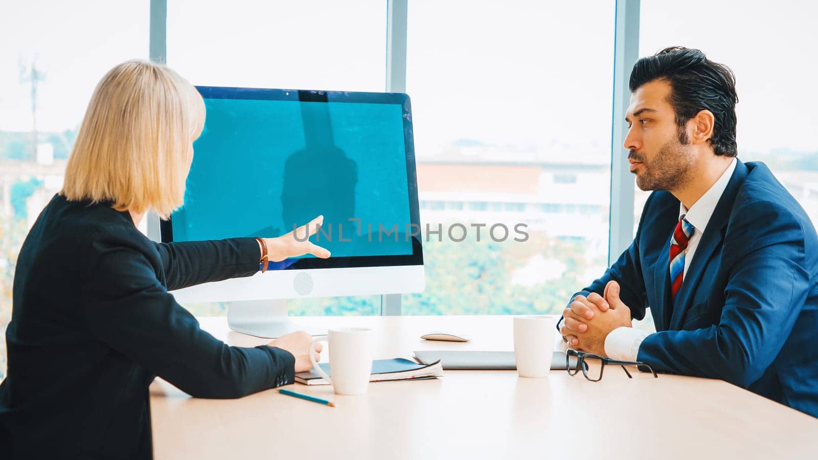 Business people in the conference room with green screen chroma key TV or computer on the office table. Diverse group of businessman and businesswoman in meeting on video conference call . Jivy