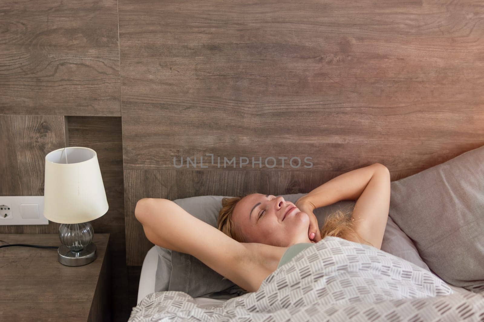 young happy girl lying on the bed in the morning, girl lying in a gray and white bed by PopOff