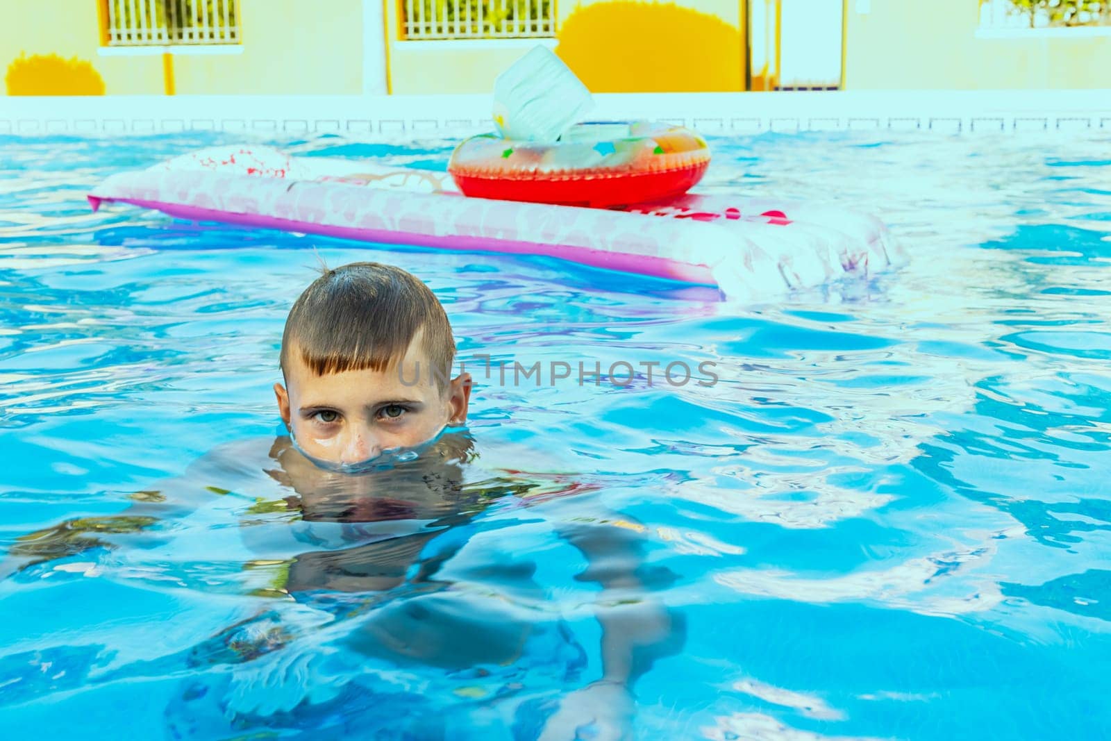 Happy boy swims and dives underwater. Active healthy lifestyle, water sports and activities with parents on summer family vacation with child. High quality photo