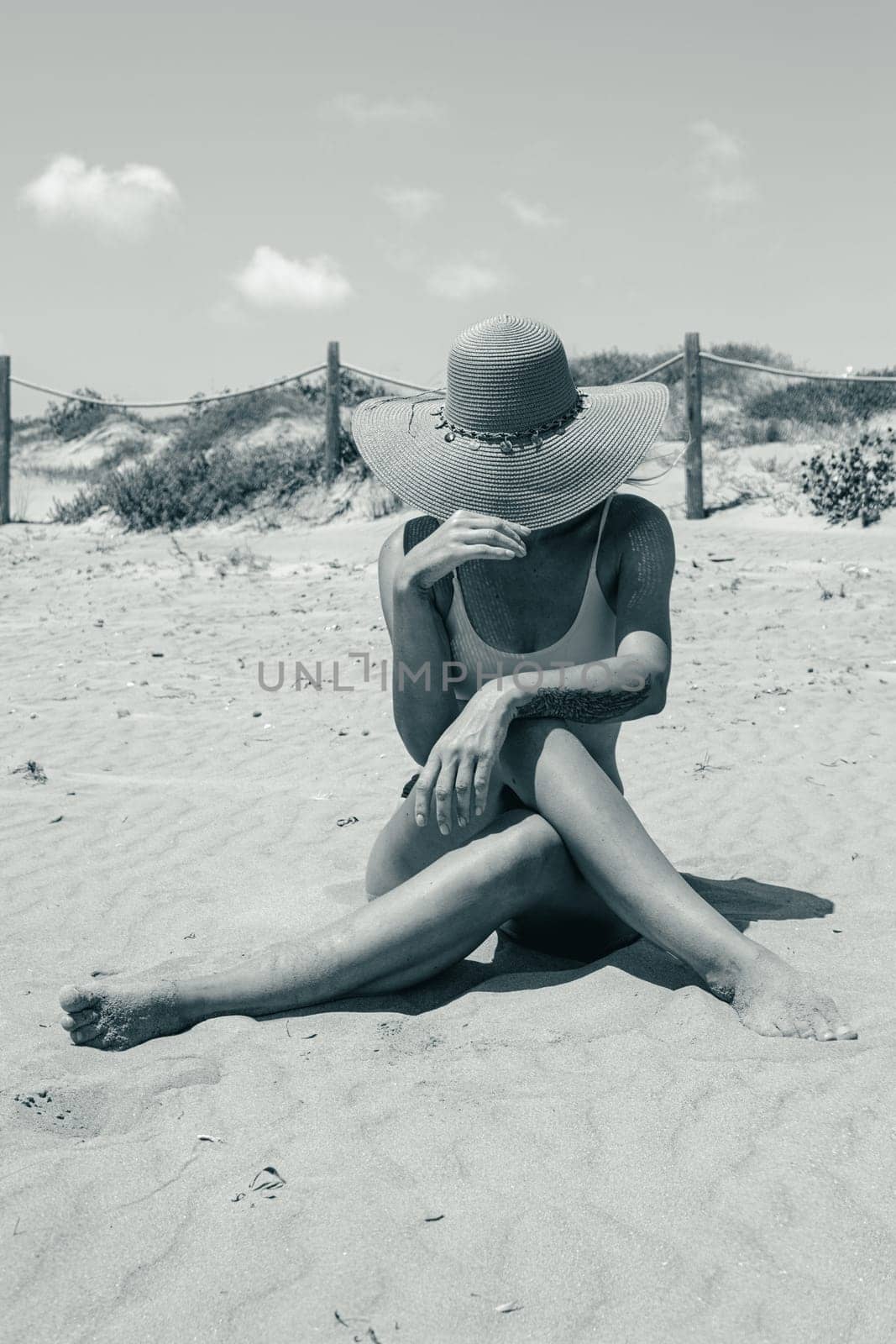 girl takes a photo on the beach in hat, there is a place for an inscription,photo is black and white by PopOff