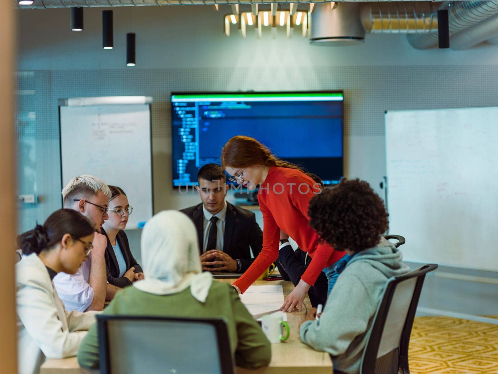 A diverse team of business experts in a modern glass office, attentively listening to a colleague's presentation, fostering collaboration and innovation.