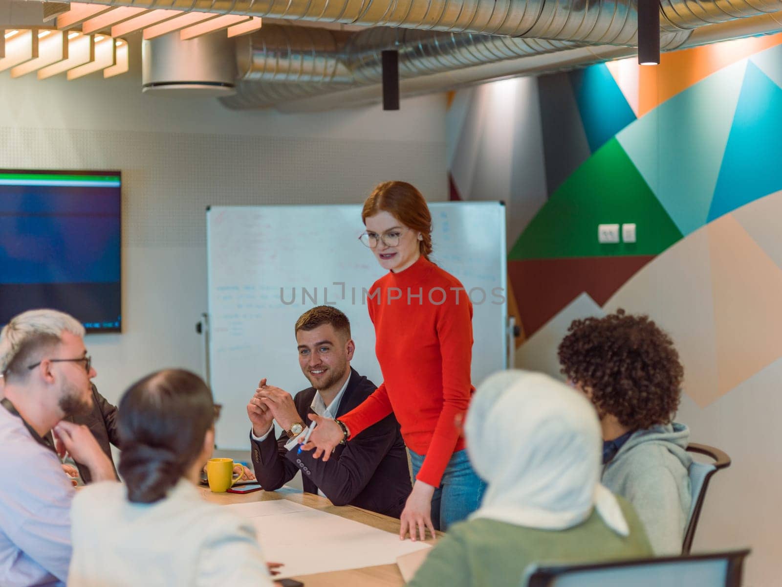 A diverse team of business experts in a modern glass office, attentively listening to a colleague's presentation, fostering collaboration and innovation by dotshock