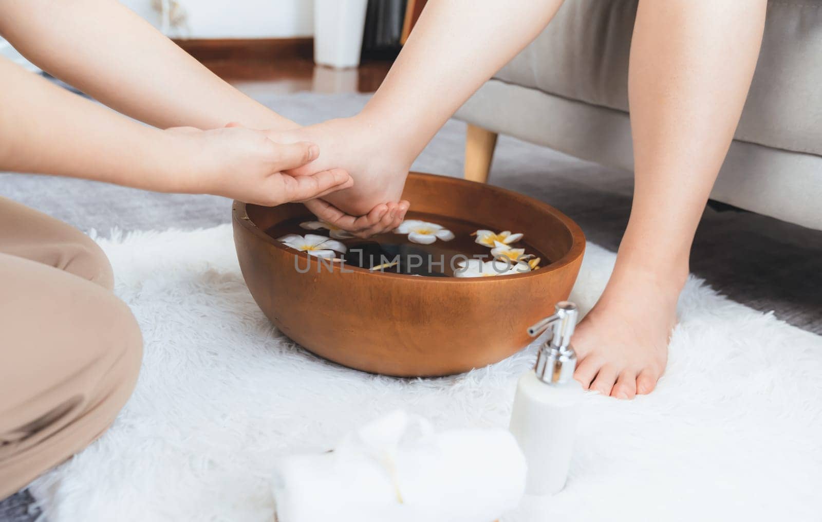 Woman indulges in blissful foot massage at luxurious spa salon while masseur give reflexology therapy in gentle day light ambiance resort or hotel foot spa. Quiescent