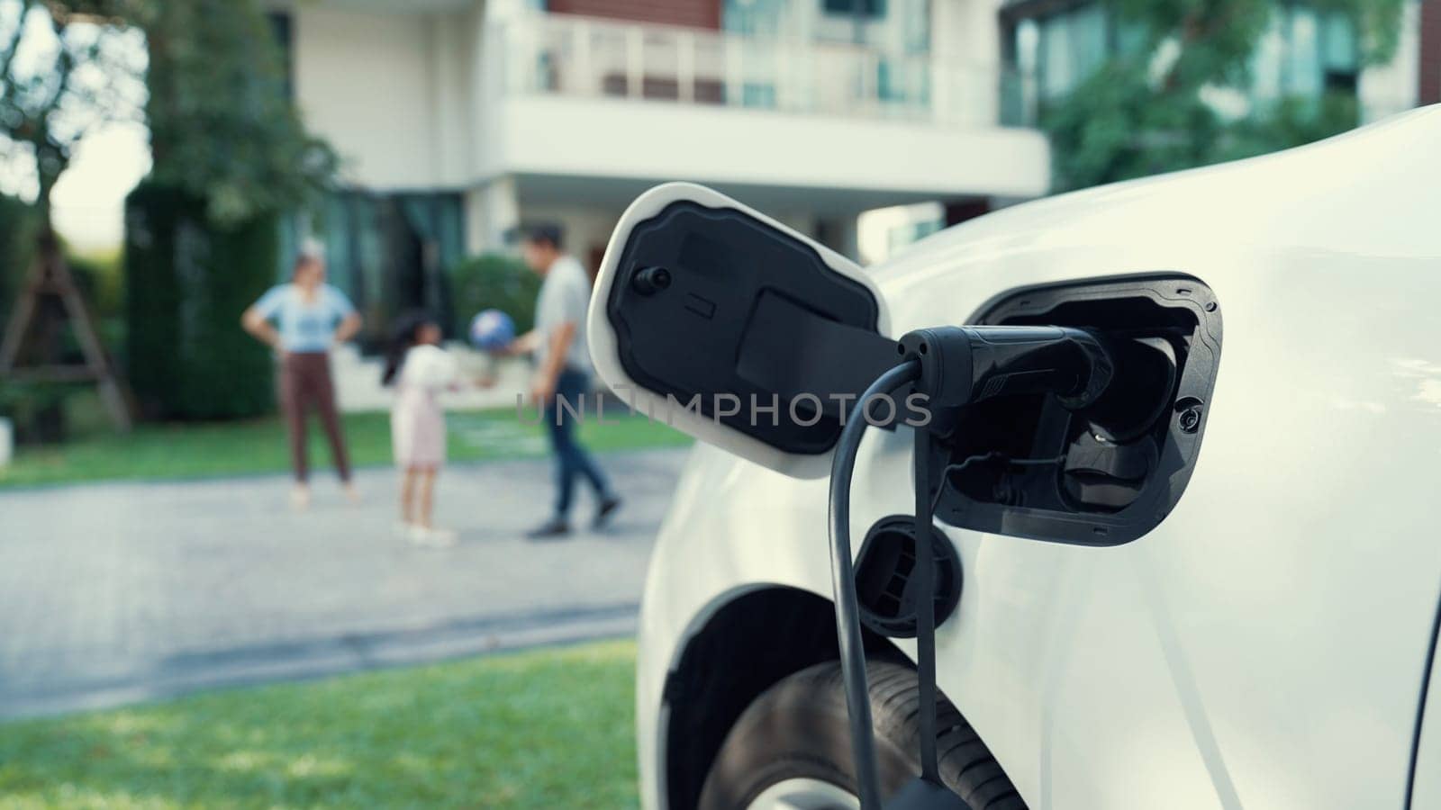 Progressive parent have returned from picking up daughter at school with EV car. by biancoblue