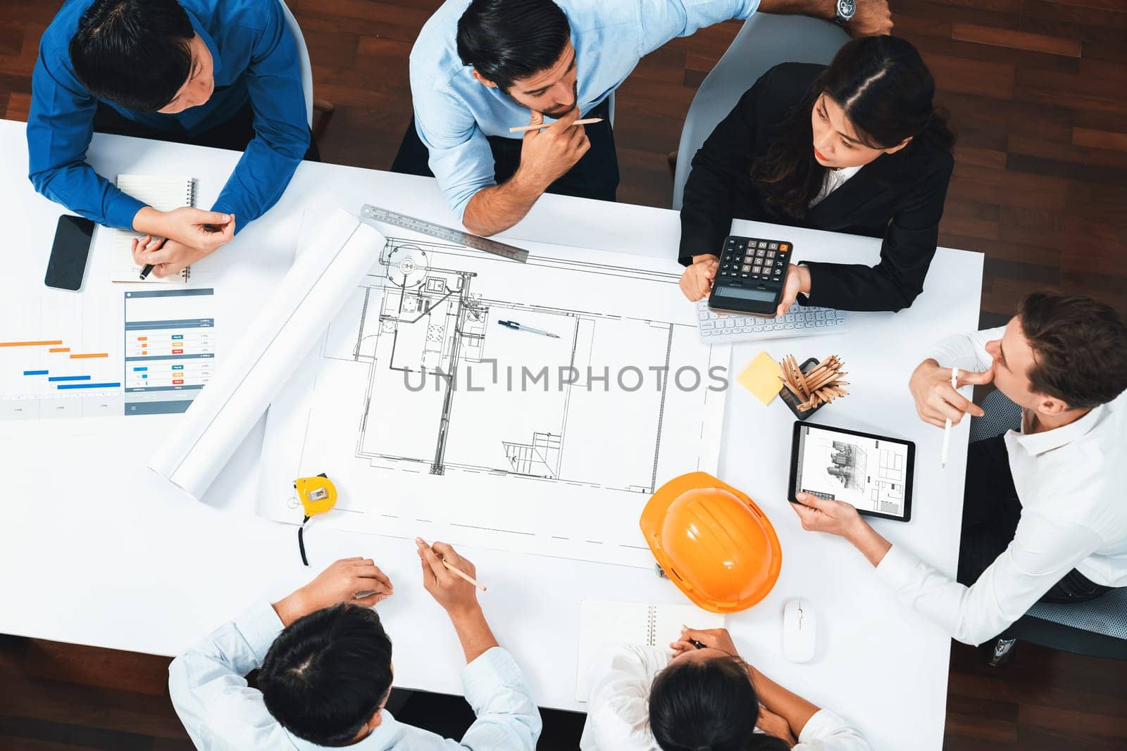 Top view banner of diverse group of civil engineer and client working together on architectural project, reviewing construction plan and building blueprint at meeting table. Prudent