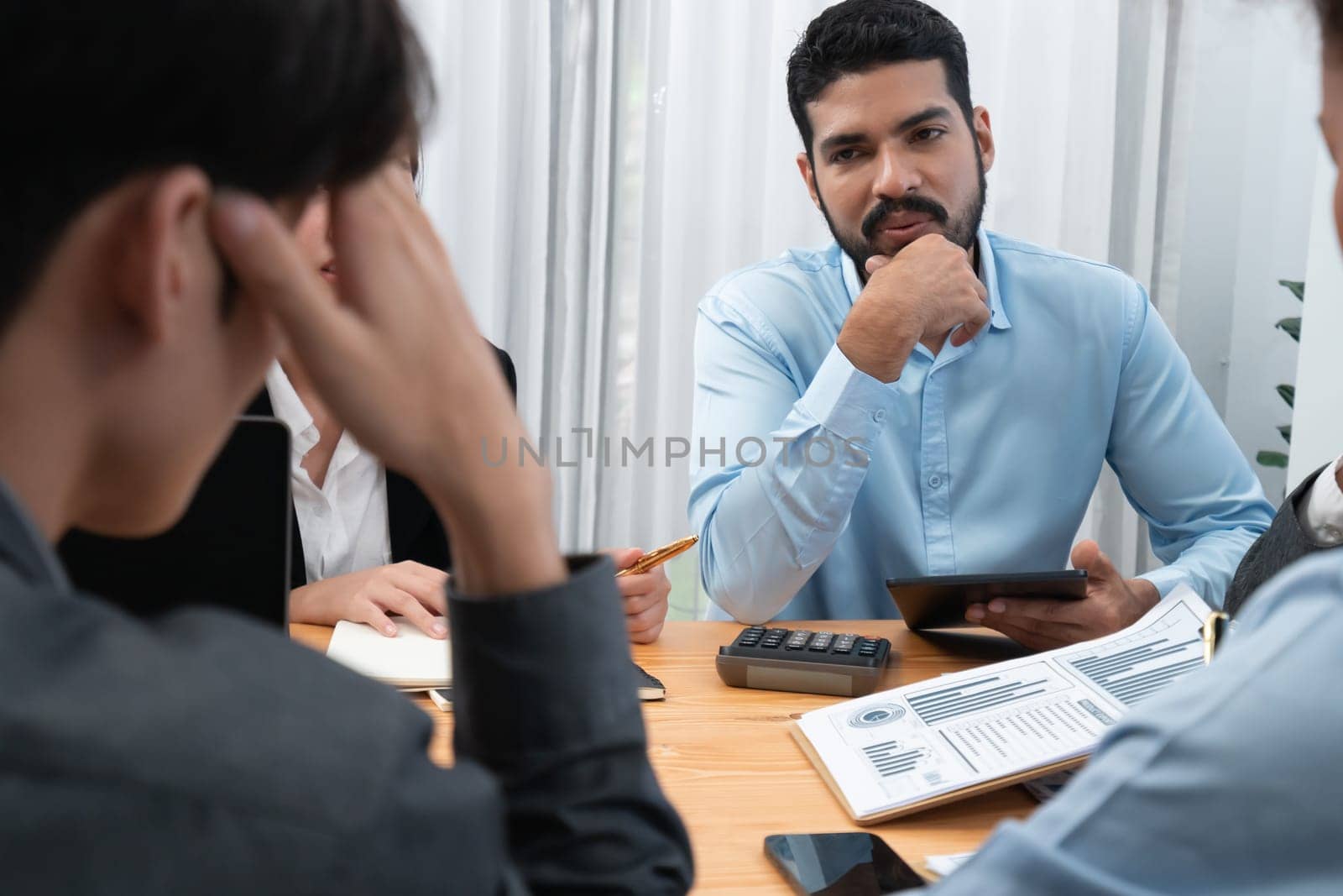 Multiracial analyst team use BI dashboard data to analyze financial report on meeting table. Group of diverse business people utilize data analysis by FIntech for business marketing decision. Concord