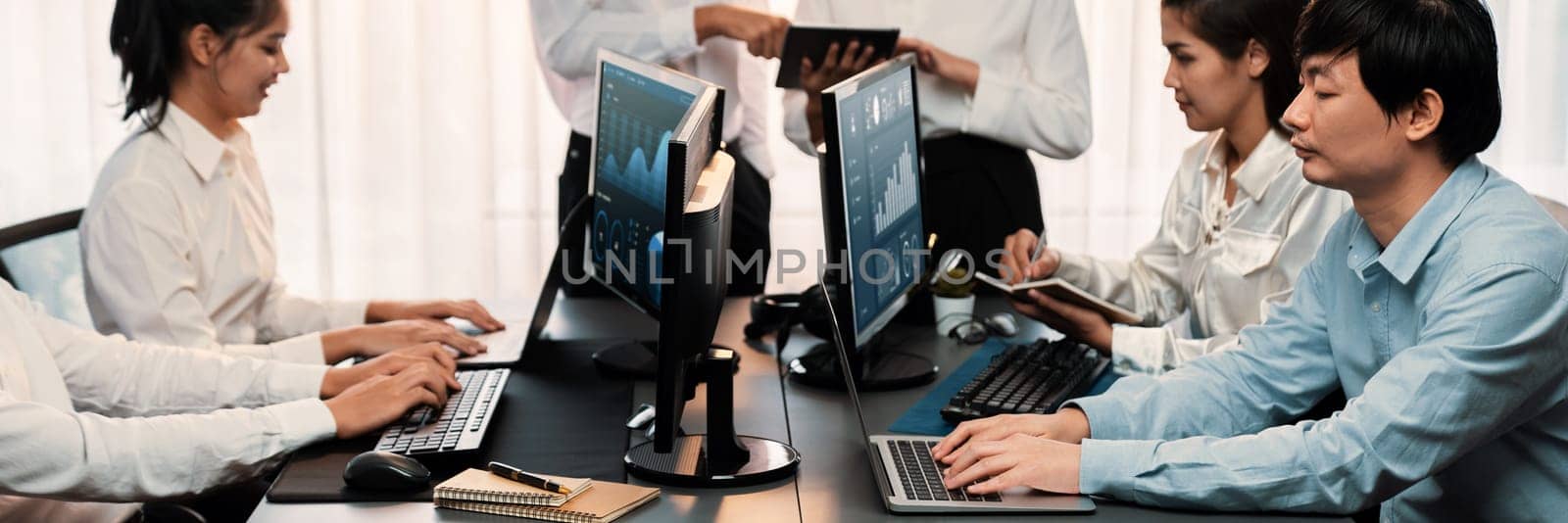 Analyst working on data analysis or BI dashboard on computer monitor. Business team analyzing financial data by Fintech in corporate office for business marketing and strategy planning. Trailblazing