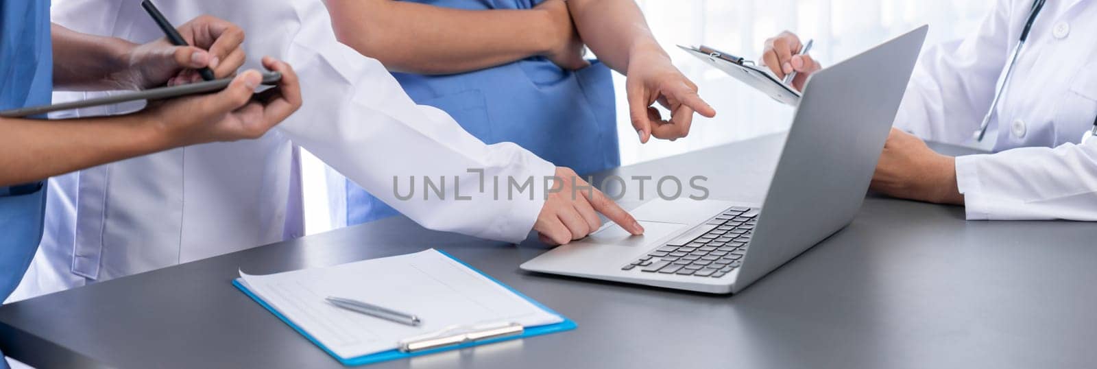 Doctor and nurse in medical meeting discussing strategic medical treatment plan together with report and laptop. Medical school workshop training concept in panoramic banner. Neoteric