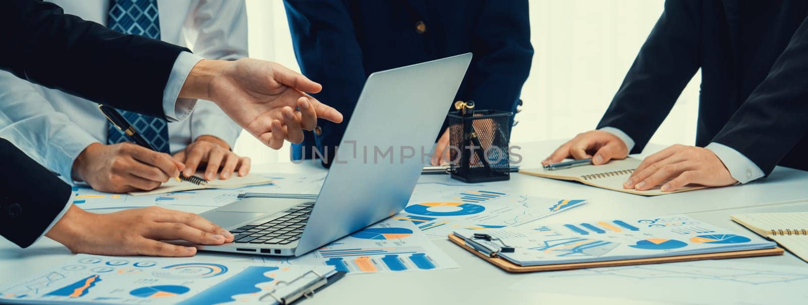 Business people in group meeting in formal attire share idea discussing report for company profit in creative workspace for start up business shot in close up view on group meeting table . Oratory .