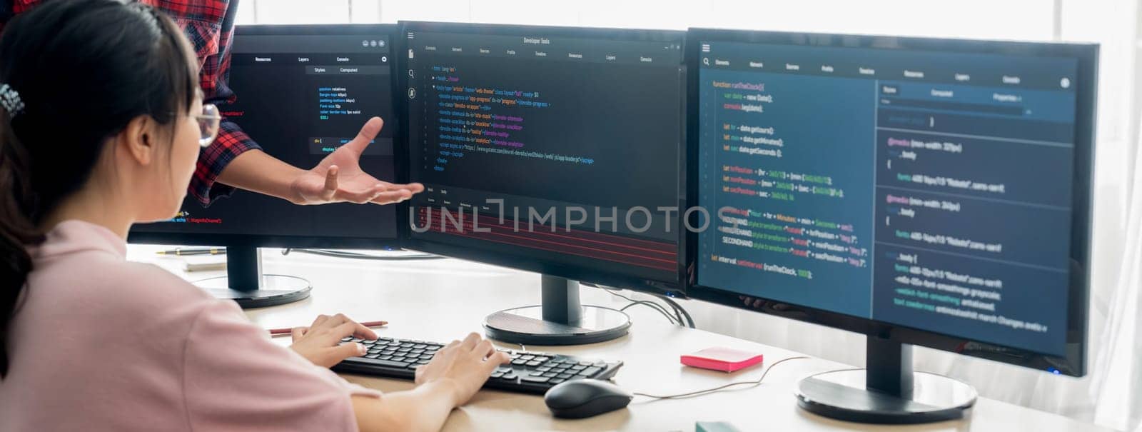 Group of professional web developer discuss about data analysis while computer screen show computer code at modern office. Close up. Digital engineering and web development concept. Burgeoning.