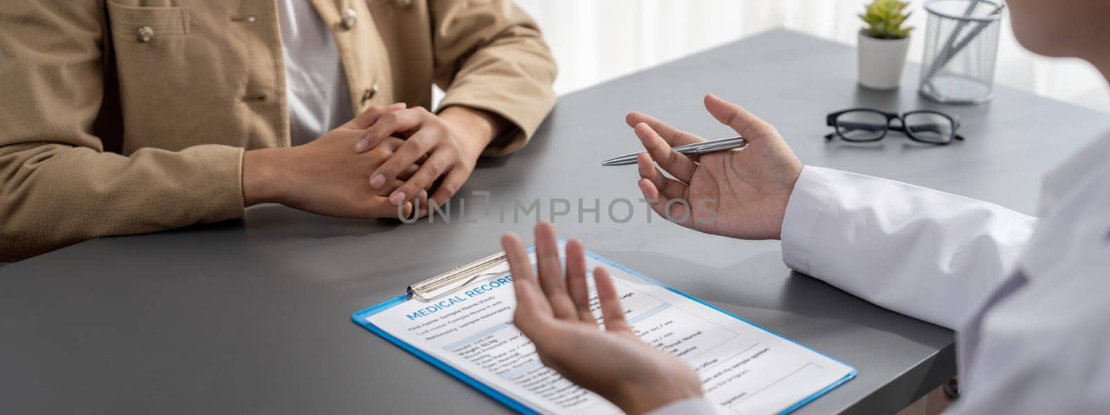 Doctor show medical diagnosis report and providing compassionate healthcare consultation to young patient in doctor clinic office. Doctor appointment and medical consult concept. Neoteric