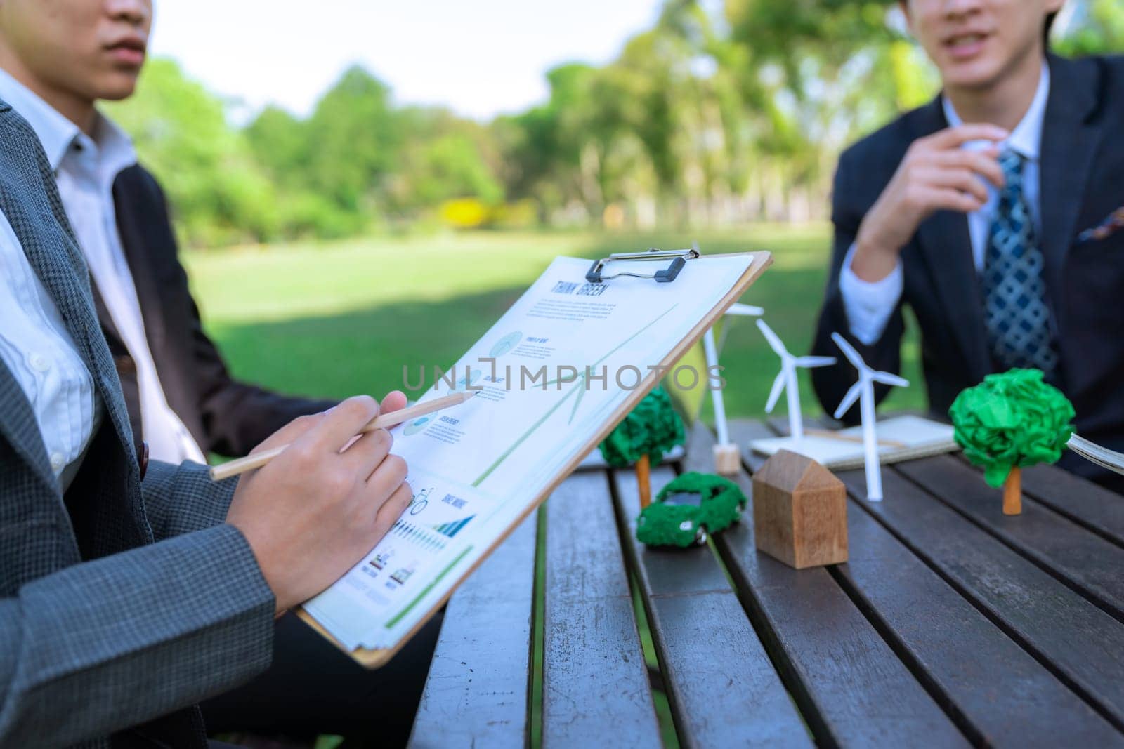 Group of asian business people presenting environmentally friendly development plan and sustainable technology project for greener future, establishing outdoor eco business office at natural park.Gyre