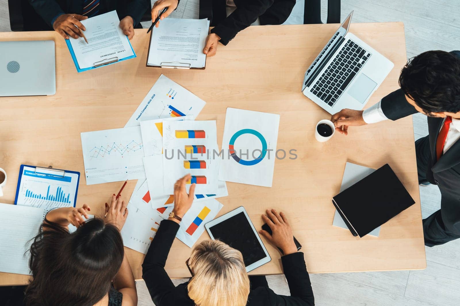 Business people group meeting shot from top view in office . Profession businesswomen, businessmen and office workers working in team conference with project planning document on meeting table . Jivy