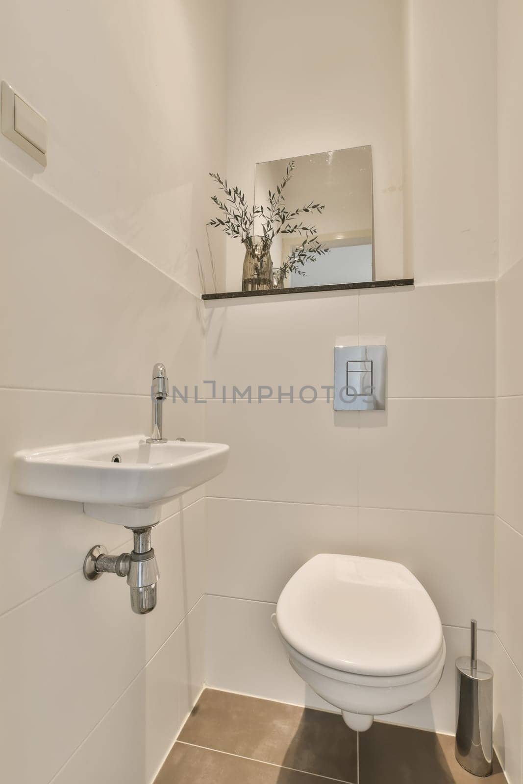 a white toilet and sink in a small bathroom with tile flooring, wall mounted mirror above the toilet bowl