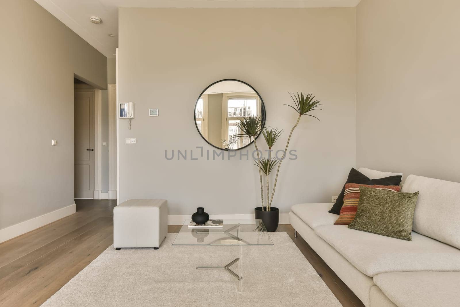 a living room with white couches and a large round mirror on the wall in the room is very clean