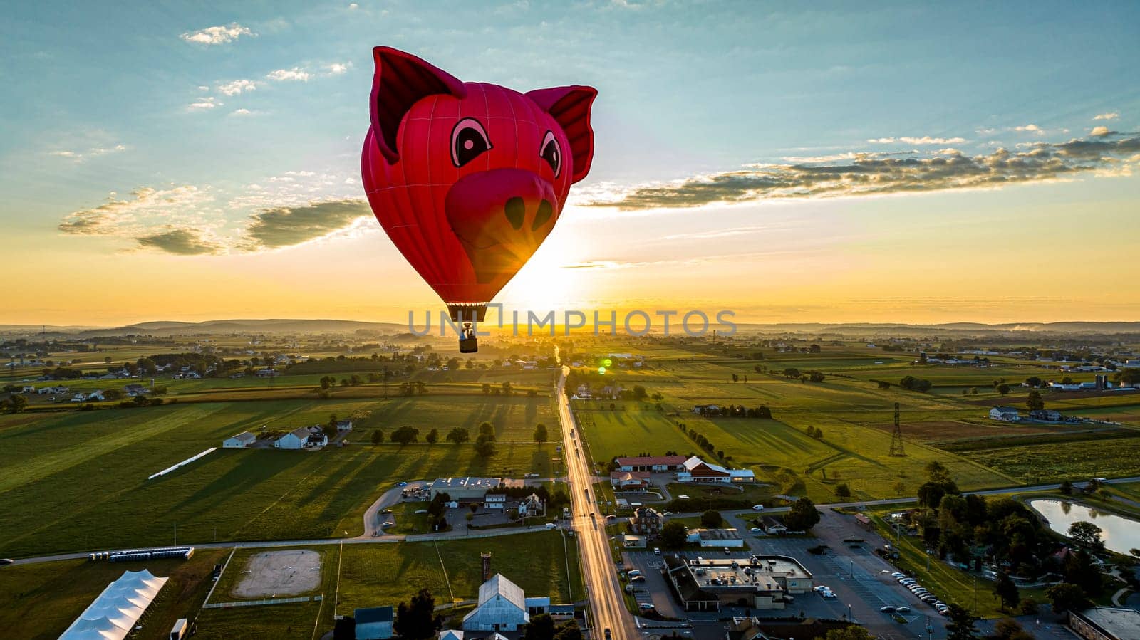 Bird in Hand, Pennsylvania, September 14, 2023 - An Aerial View of a Pig Head Hot Air Balloon, Floating Over Pennsylvania Farmlands at Sunrise, on a Summer Day