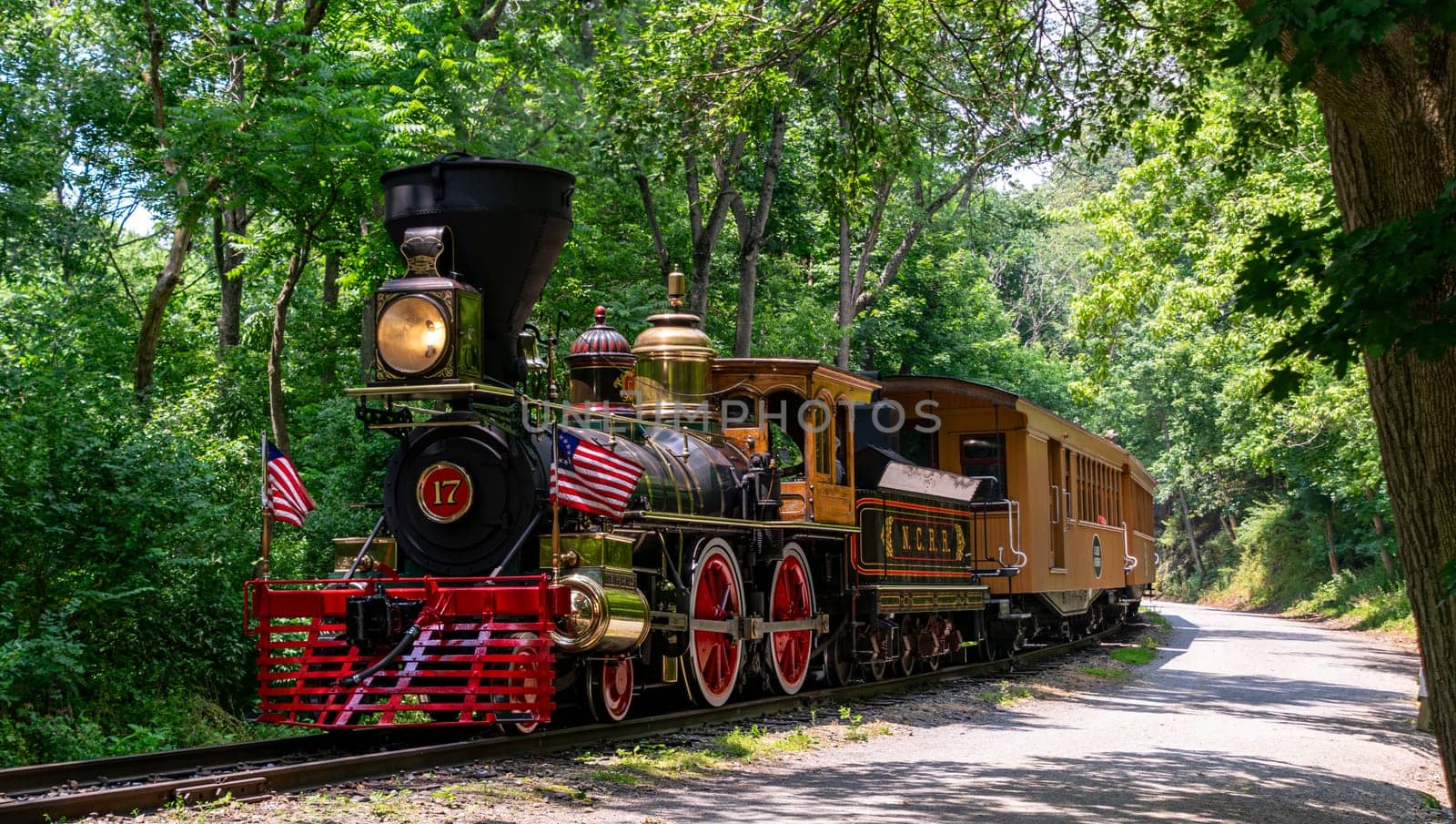 New Freedom, Pennsylvania, June 17, 2023 - A View of an Approaching Steam Passenger Train Blowing Smoke on a Sunny Summer Day