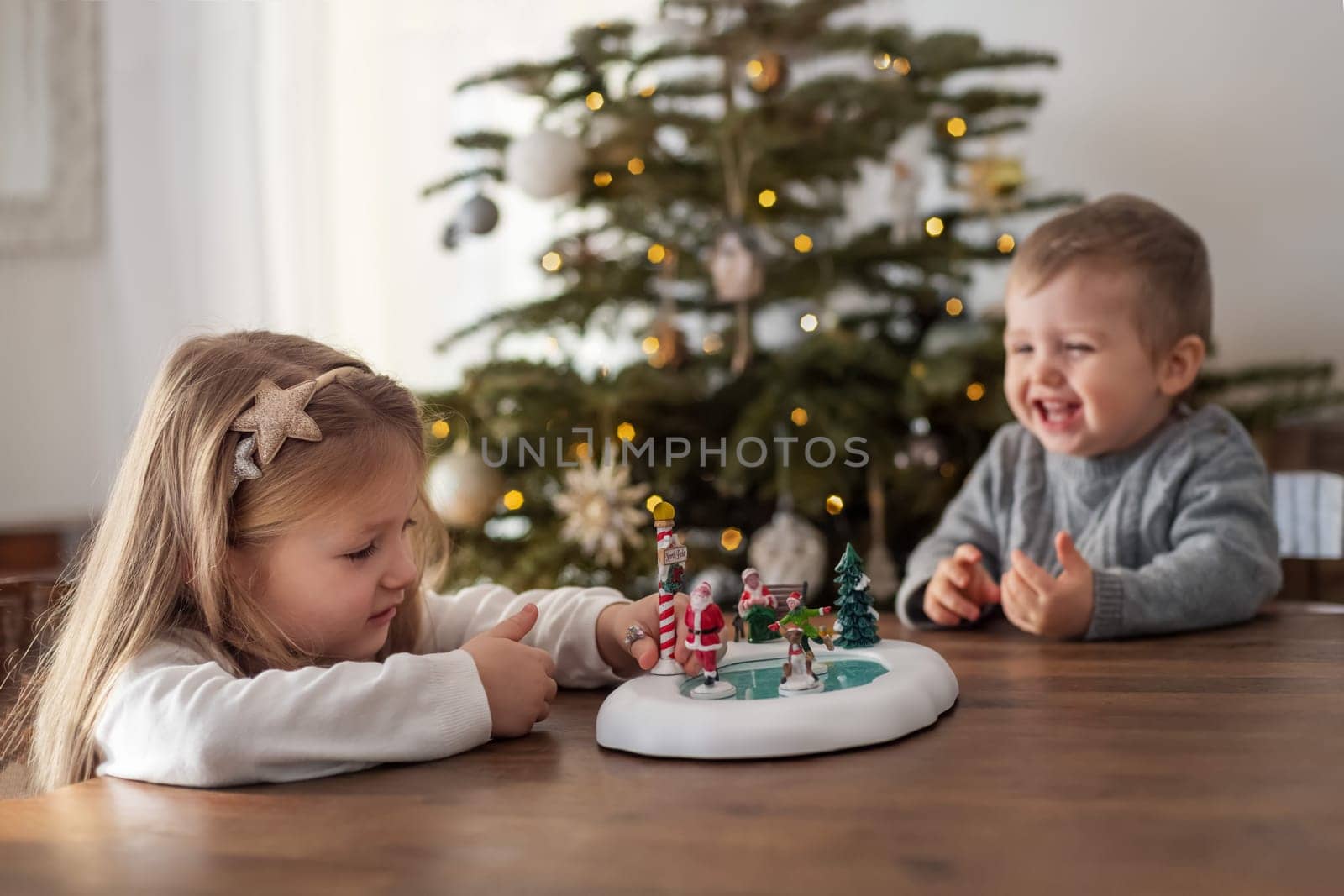 Sister and brother play with ceramic figures for Christmas