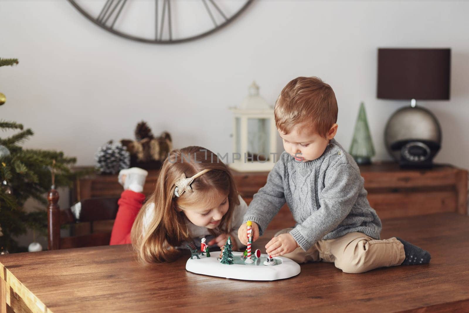 Sister and brother play with ceramic figures for Christmas