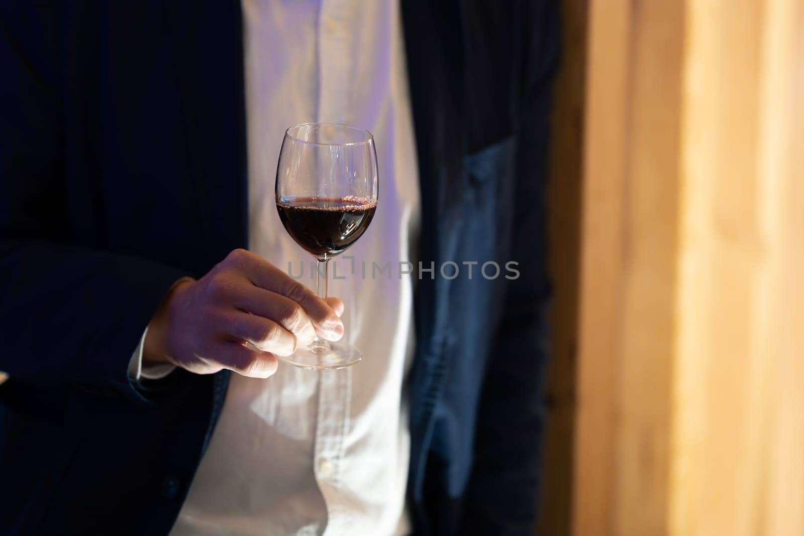 Hand holding a wine glass by Studia72