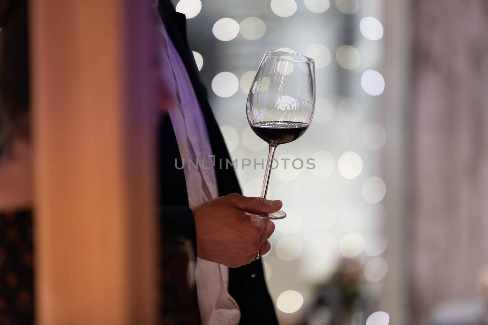 A formally dressed individual holding a wine glass, portraying a sense of sophistication.