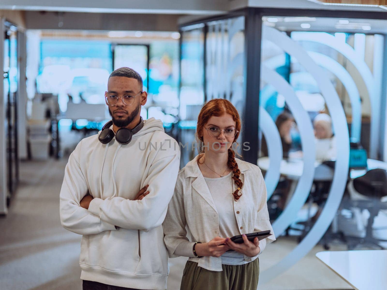 In a modern office African American young businessman and his businesswoman colleague, with her striking orange hair, engage in collaborative problem-solving sessions by dotshock