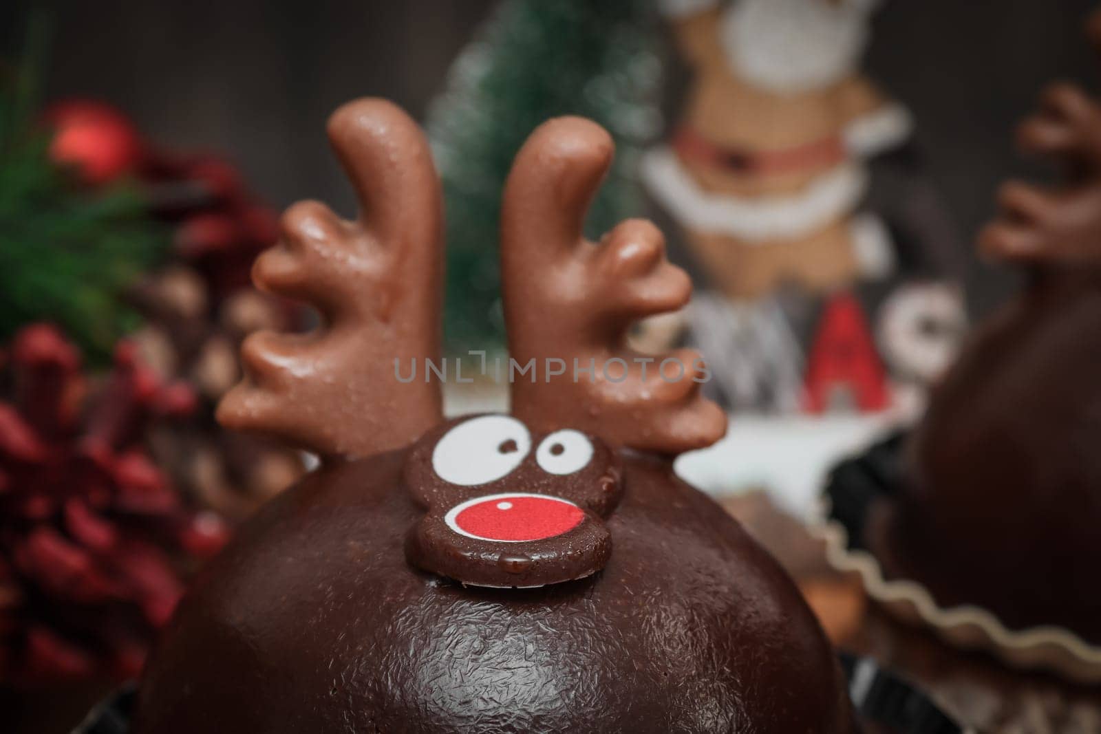 One chocolate deer on a wooden tray with christmas decoration on the table, side view close-up.