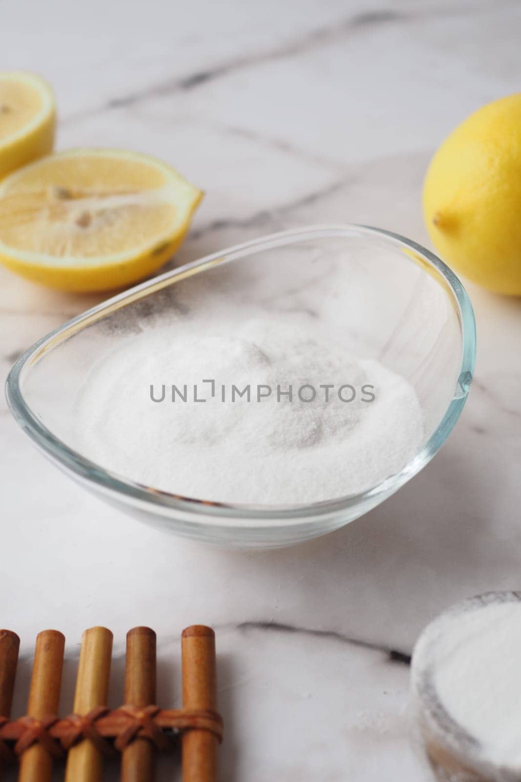 Baking soda and whole lemon on table by towfiq007