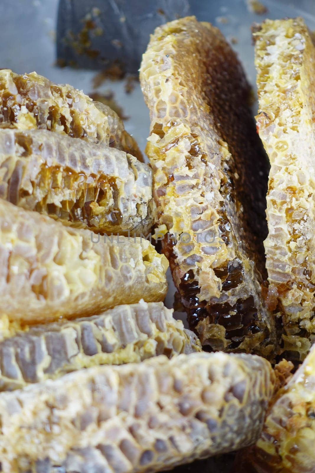 close up of fresh honey with comp in a jar .