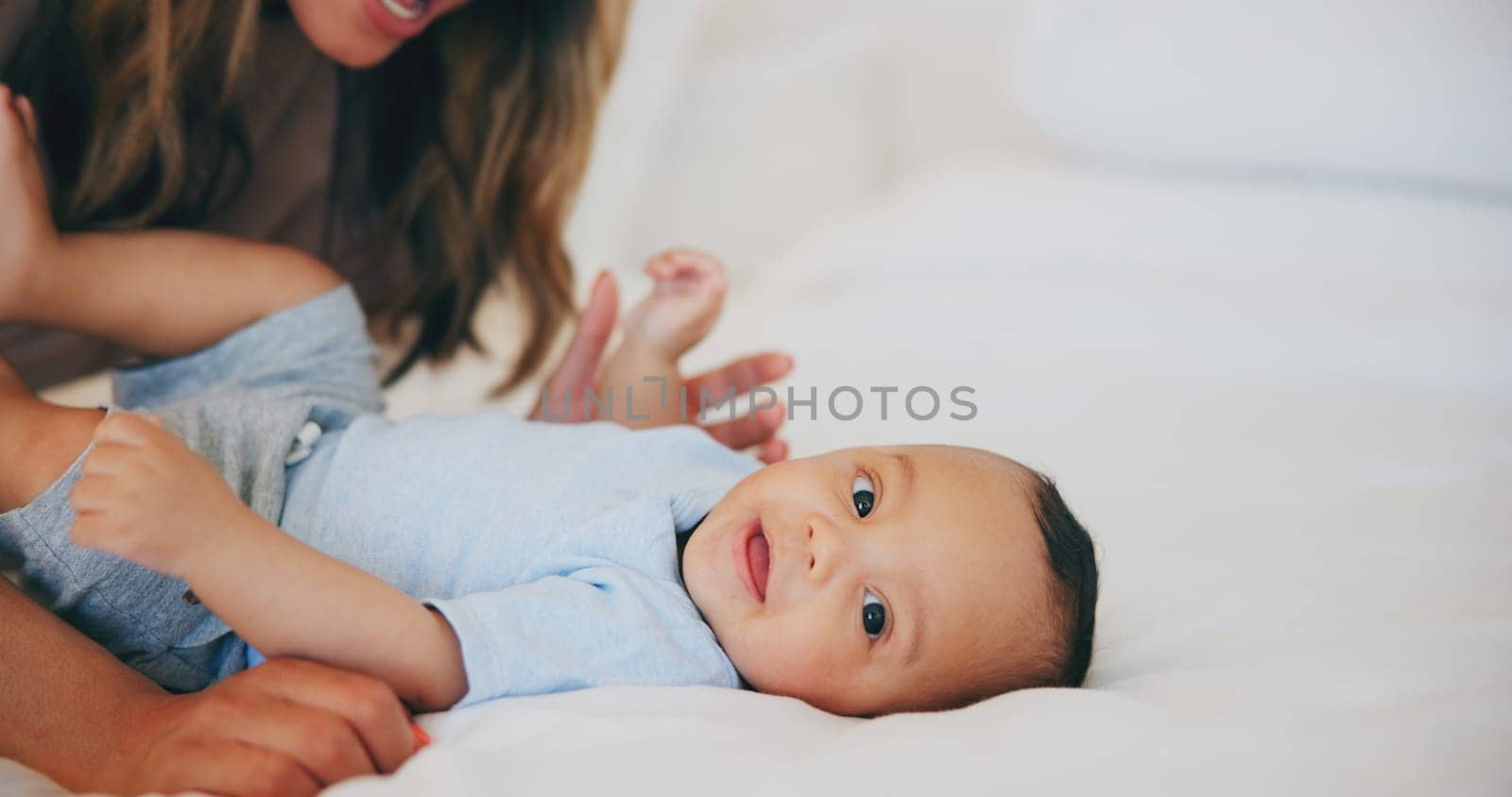 Hands, love and portrait of baby in bed with mother at home, play and family bonding together. Face of child, mom and closeup of infant in bedroom, security and care of toddler or kid for growth.