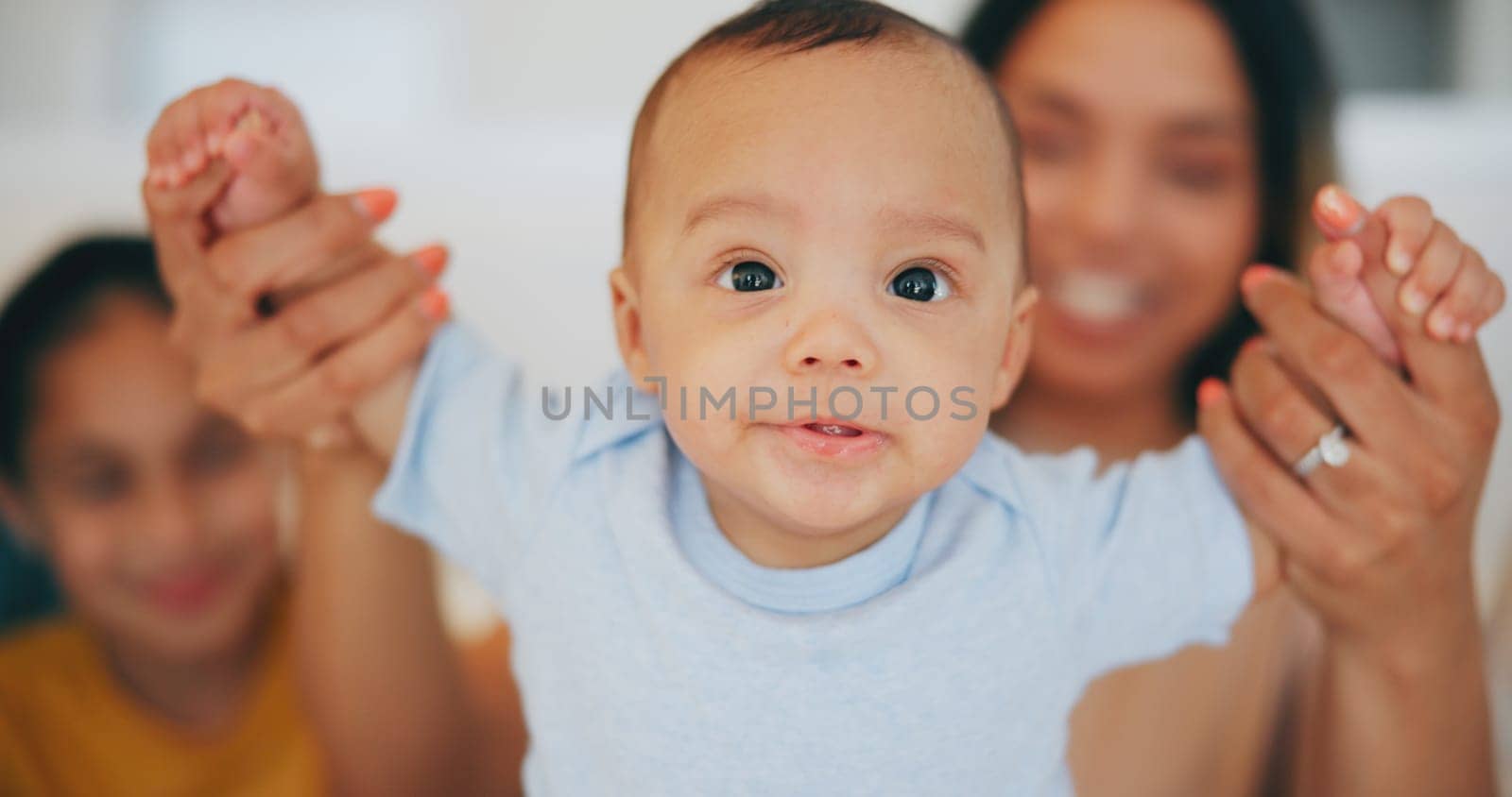 Portrait, baby and holding hands with a family in the living room of their home together for bonding. Face, cute or adorable with an infant boy, his mother and sister in their apartment closeup.