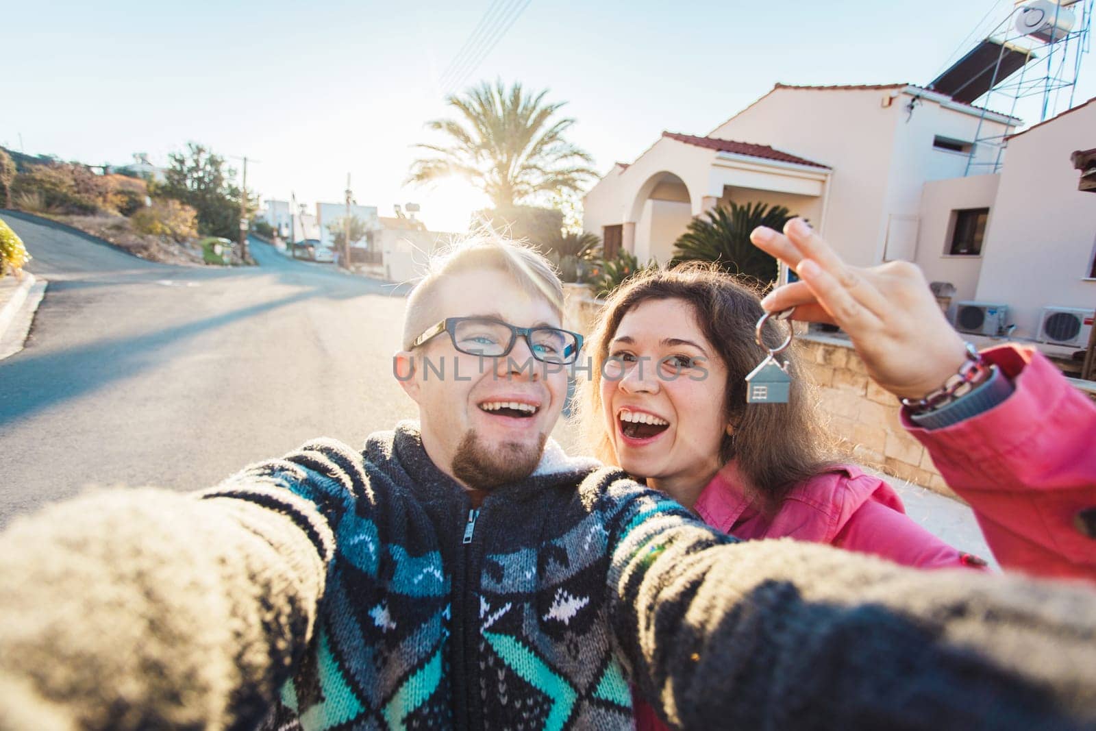 Happy smiling young couple showing a keys of their new house.