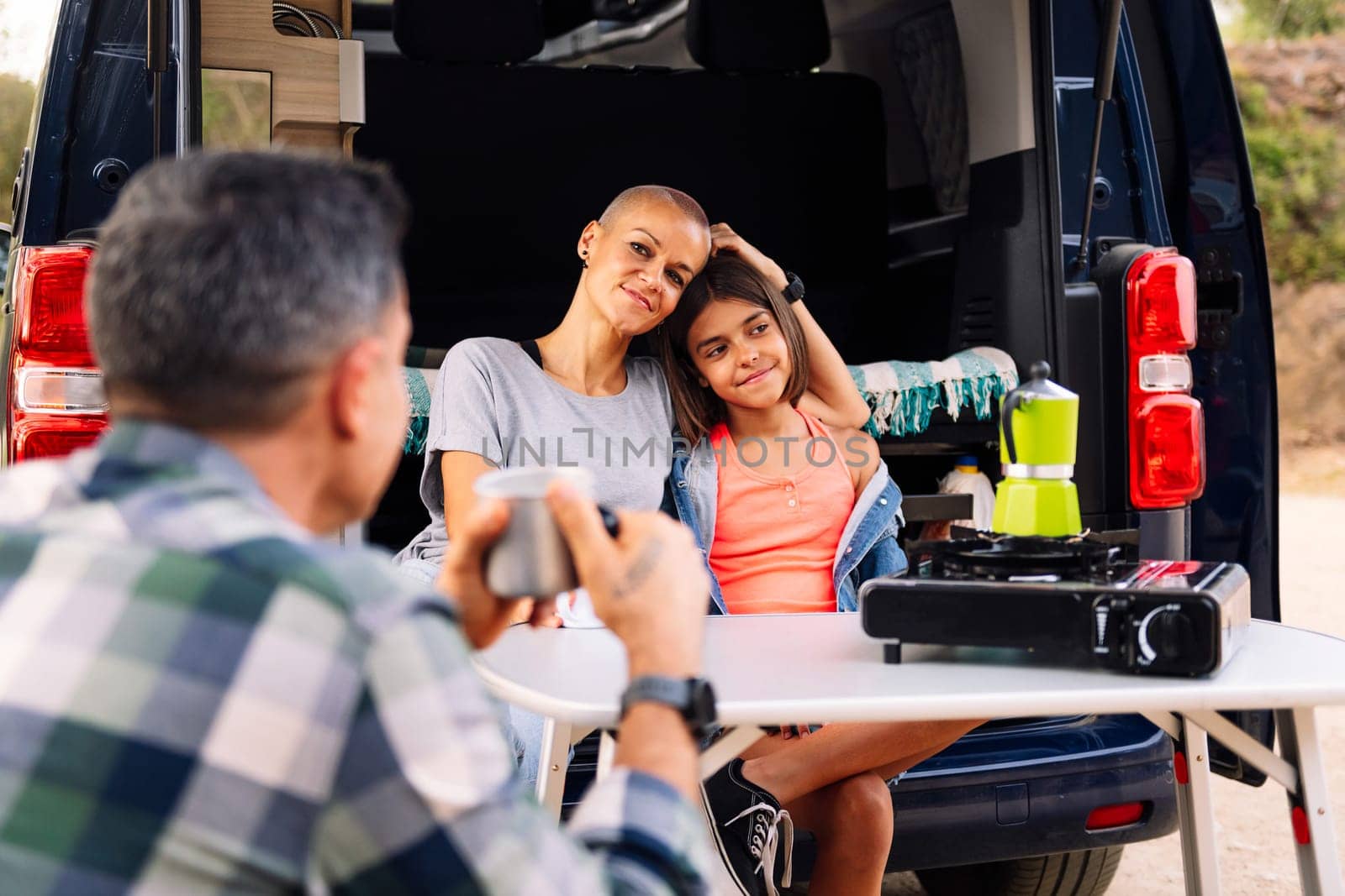 family camping in the countryside with their camper van, concept of active tourism in nature and outdoor activities with children