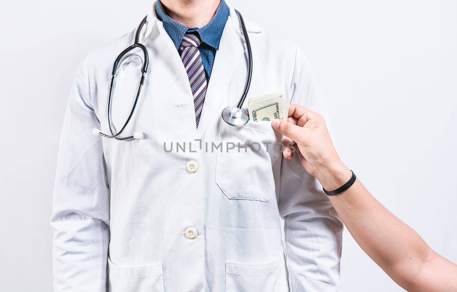 Medical bribery concept. Hand of person bribing doctor, Hands putting money in doctor pocket