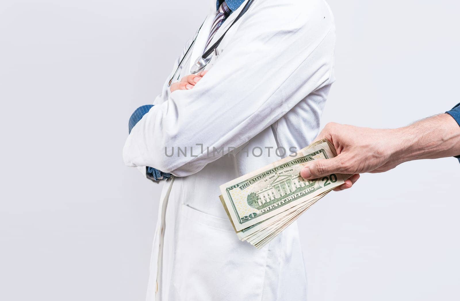 Hand of person bribing doctor. Hands putting money in doctor pocket, Medical bribery concept