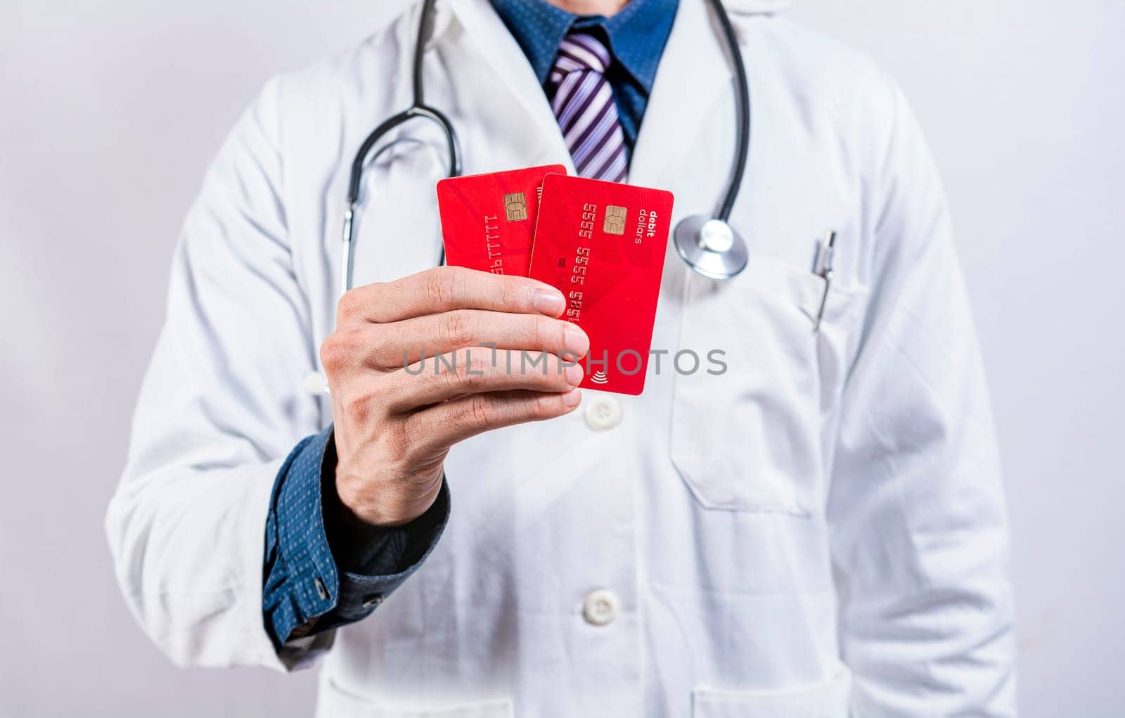 Doctor hands holding credit cards. Doctor holding two credit card isolated. Concept of medical card payments by isaiphoto