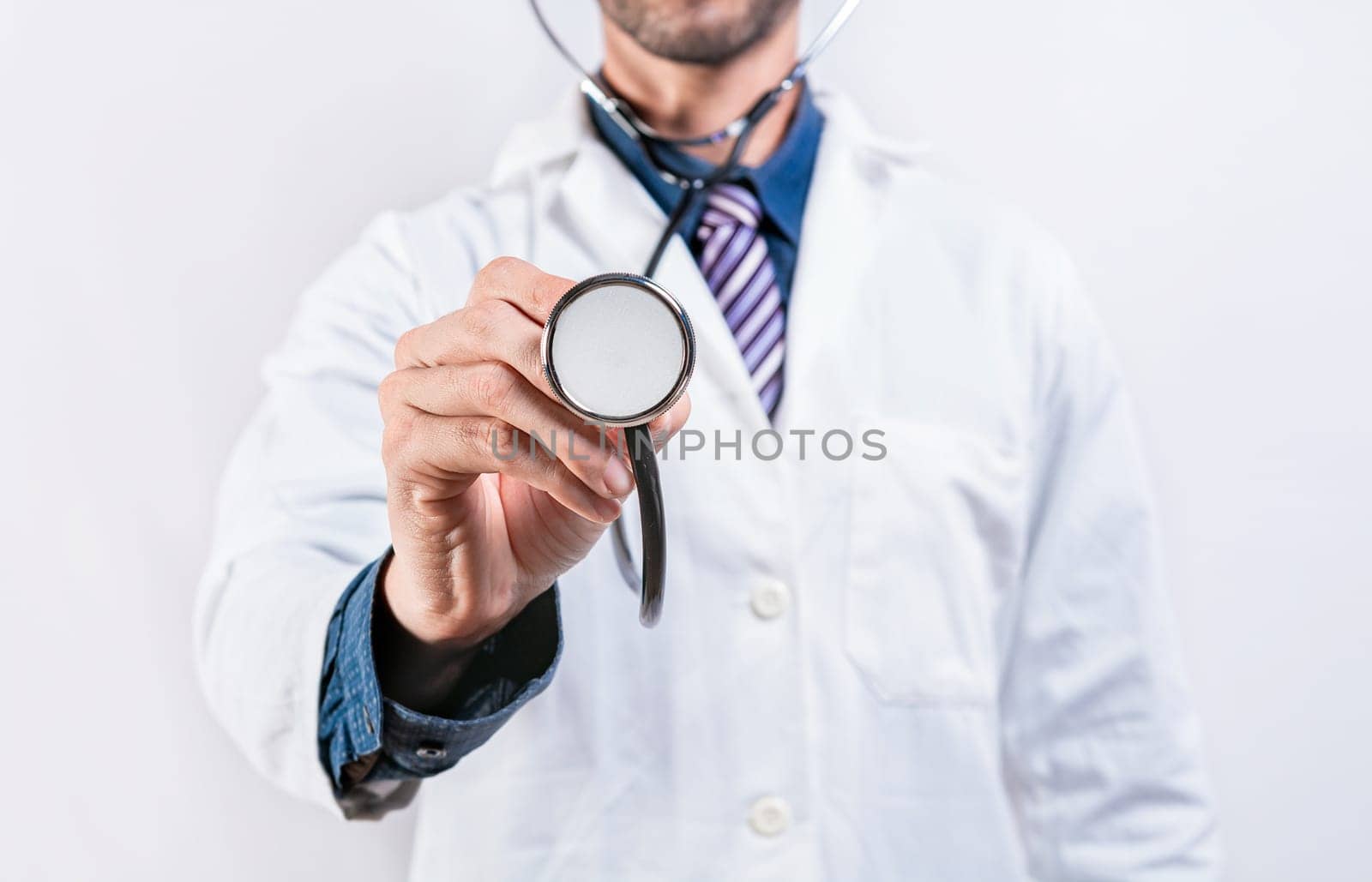 Close up of doctor holding stethoscope isolated. Unrecognizable doctor holding a stethoscope on white background by isaiphoto