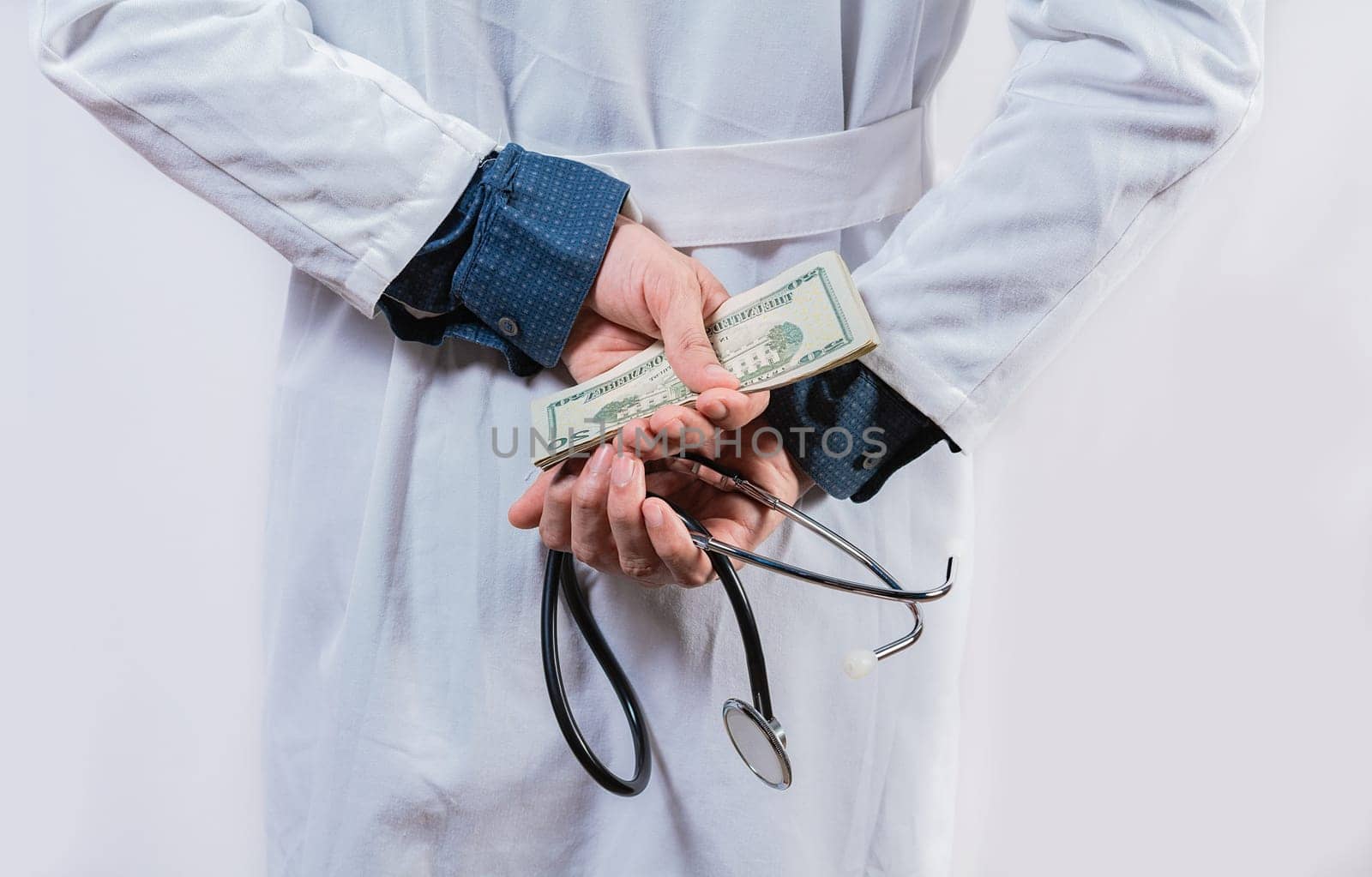 Dishonest doctor hiding money. Medical corruption and bribery concept, Corrupt doctor hiding money back