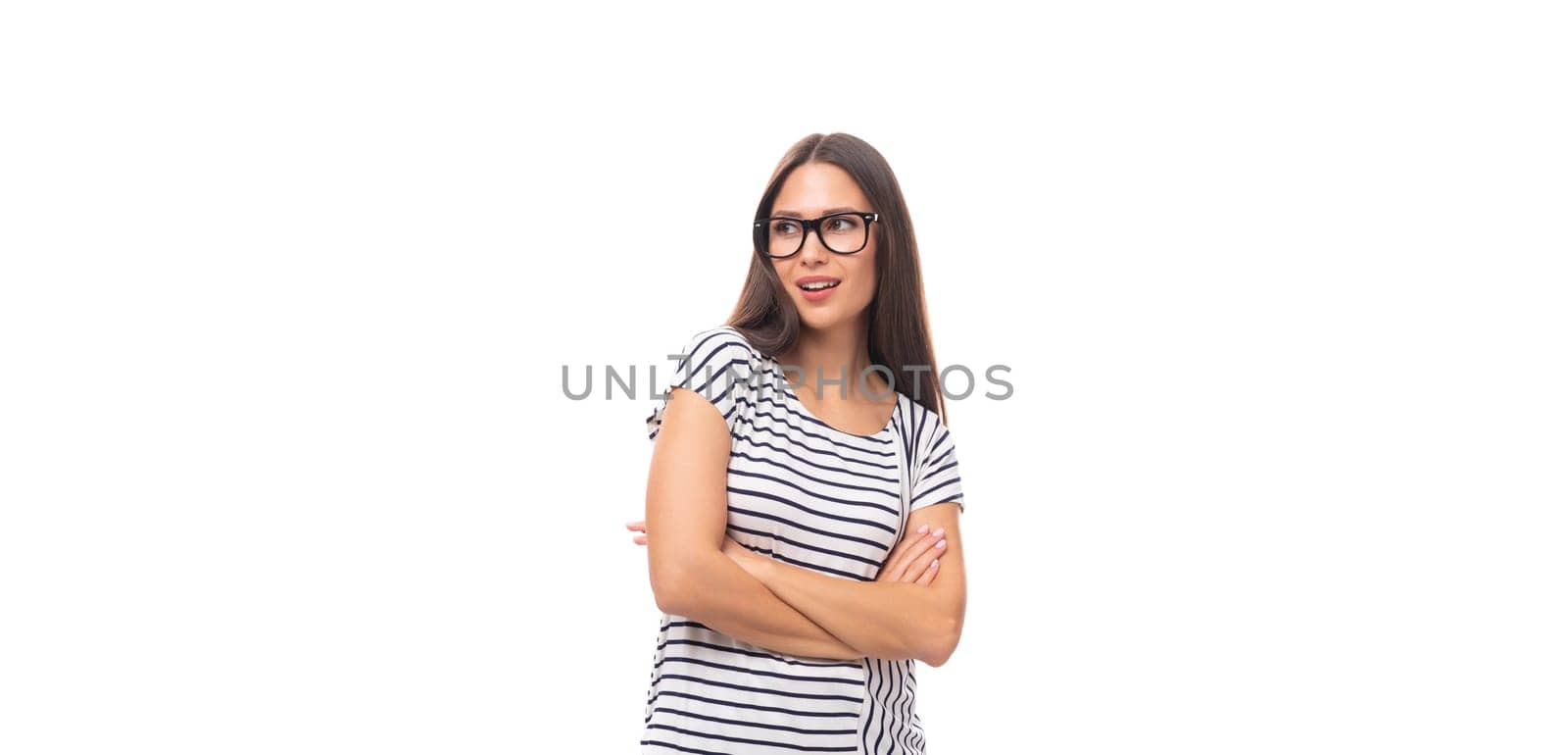 portrait of a young cute casual european woman with long dark hair dressed in a striped t-shirt on a white background with copy space.