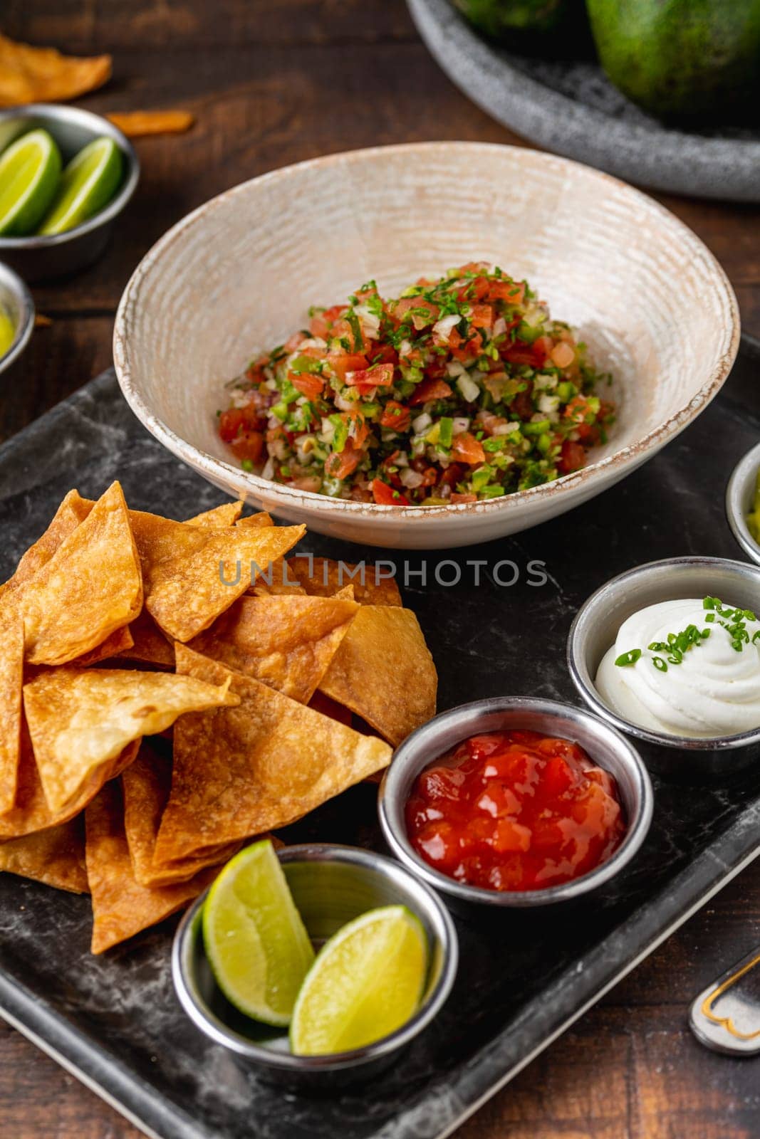 Pico de gallo from Mexican cuisine with dipping sauces on wooden table by Sonat