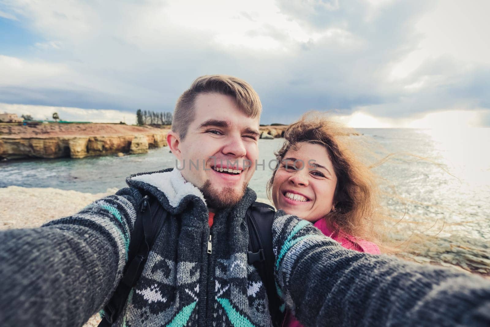 We love traveling. Adventure Selfie. Caucasian young couple taking selfie while they walking on mountains near the sea