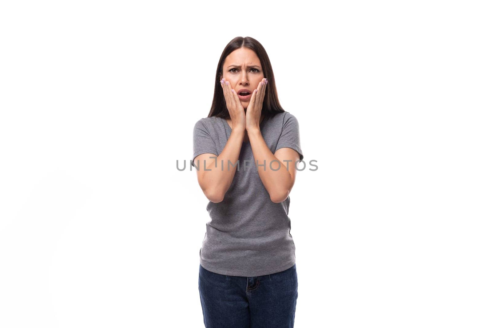 young surprised upset european brunette woman dressed in gray basic t-shirt with branding mockup.