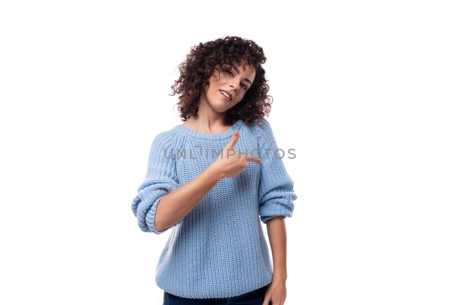 young authentic brunette woman with curled hair wearing a blue sweater by TRMK